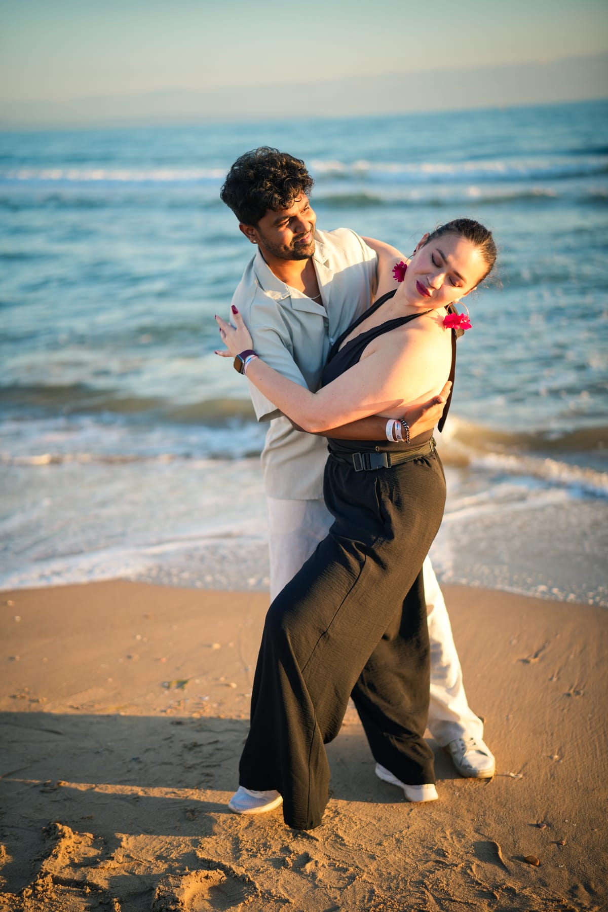 A couple dancing on the beach at sunset